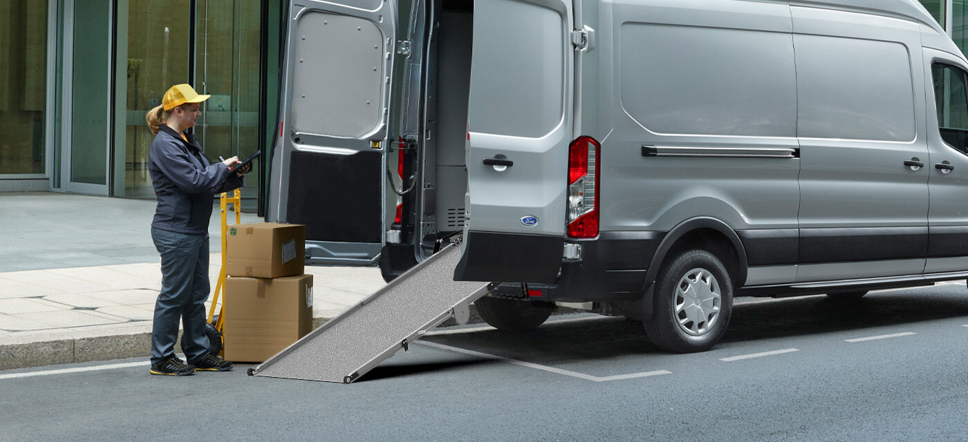 A woman preparing to dolly boxes into a cargo van