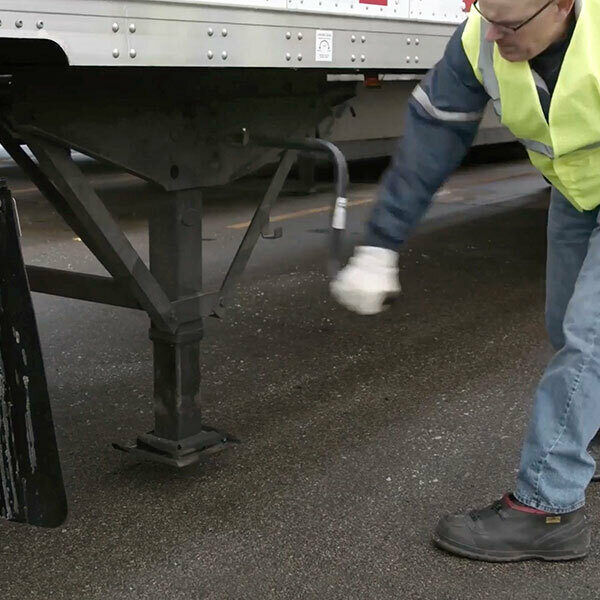 A man in a safety jacket cranking a landing gear