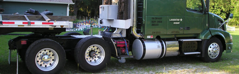 A green semi truck with a flatbed trailer featuring a link 6x2