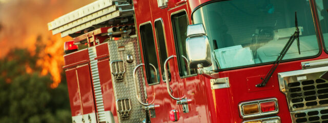A fire truck in front of a forest fire