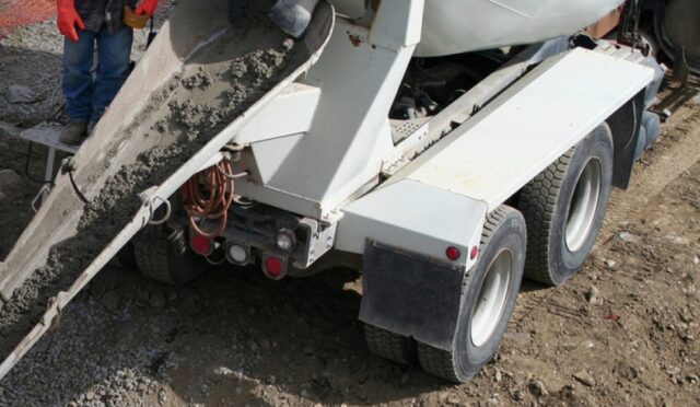 A cement mixer dumping cement with a chute