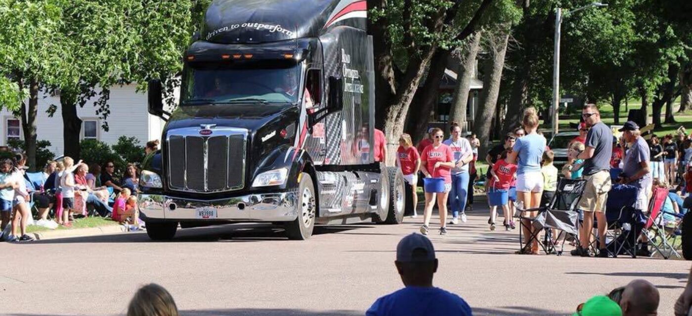 Link employees walking with the Link semi truck cab in a parade