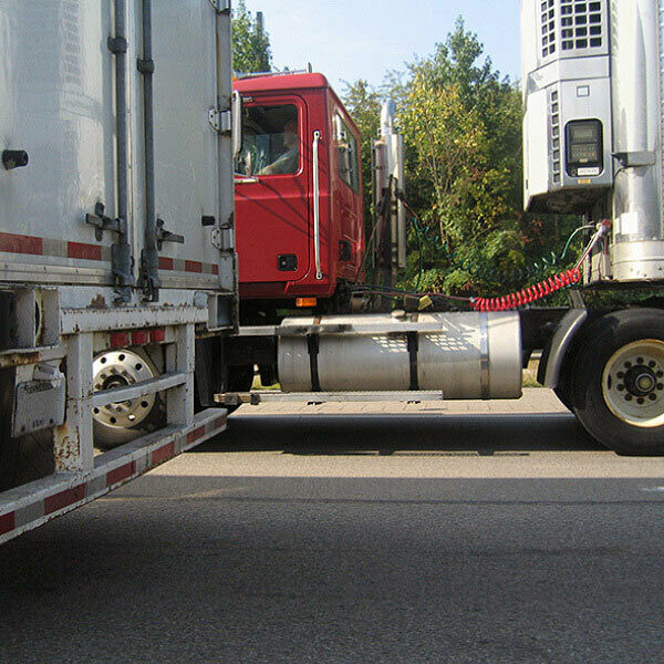 A side view of the back of a semi cab hauling a trailer