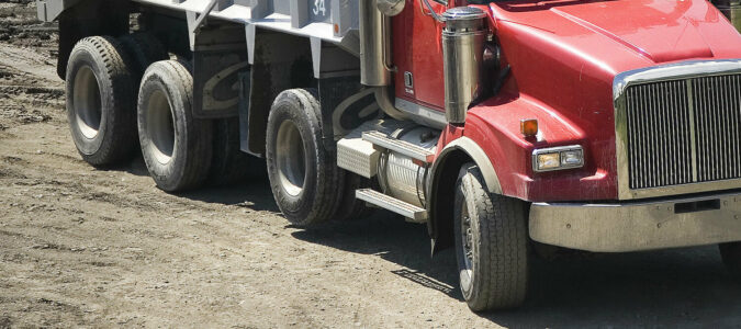 Tires on a dump truck, including a non-steerable lift axle