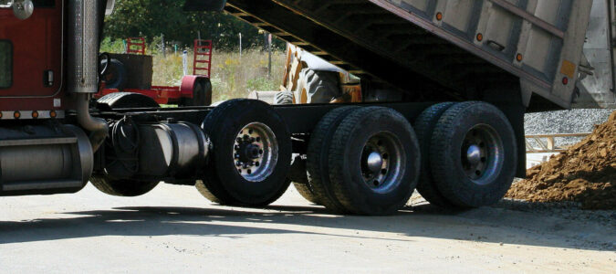Tires on a dumping dump truck, including a non steer lift axle