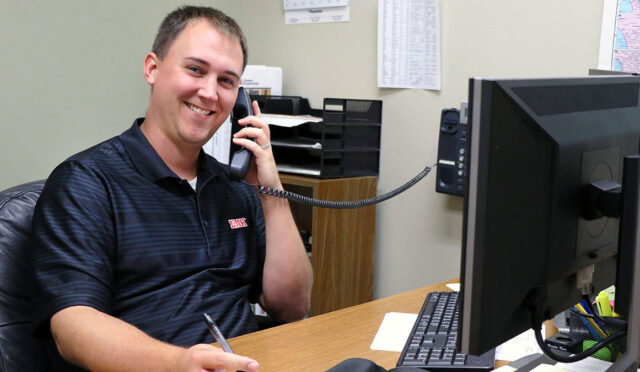 Man smiling while taking call on phone