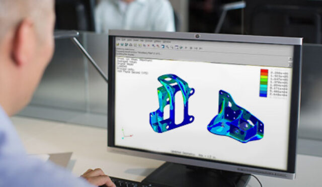 A man looking at rendered parts on a computer screen