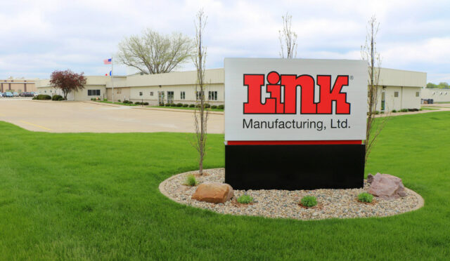 A metal standing sign that reads "Link Manufacturing, Ltd." in front of the administration building on the Sioux Center, IA Link Mfg. Campus