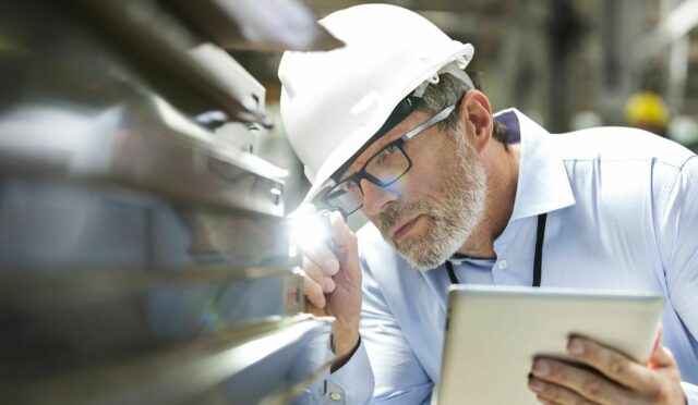 Man inspecting part with flashlight